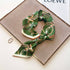 Green WINDING RIVER stirrup loop scarf with a stylish, textured design, perfect for adding a pop of color to your outfit.
