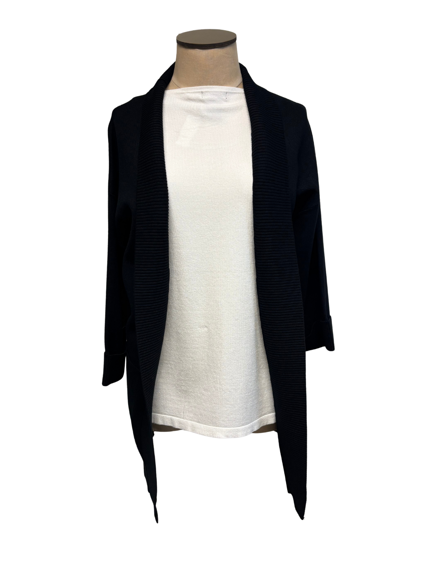 Black cardigan over a white top on a mannequin against a white background