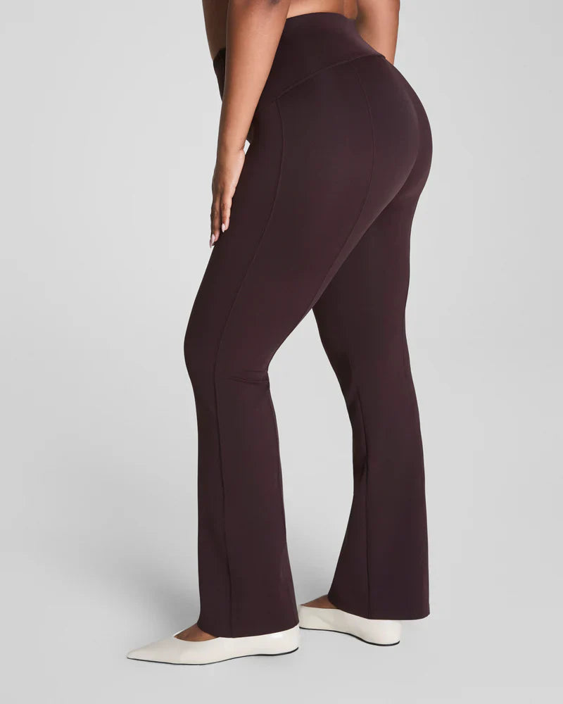 Brown SPANX Dressy Micro Flare Leggings shown on a model, featuring a fitted waistband and flared leg design.