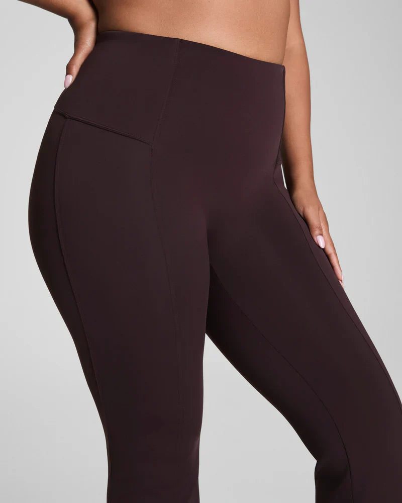 Brown SPANX Dressy Micro Flare Leggings shown on a model, highlighting the fitted style and flare design.