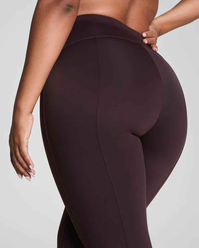 Brown SPANX dressy micro flare leggings shown on a model, highlighting the fitted design and flare leg style.