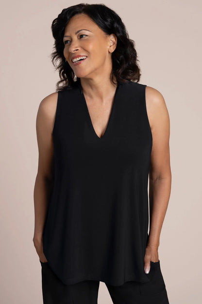 A woman wearing a sleeveless black V-neck top and black pants by Sympli Deep V Trapeze Tank