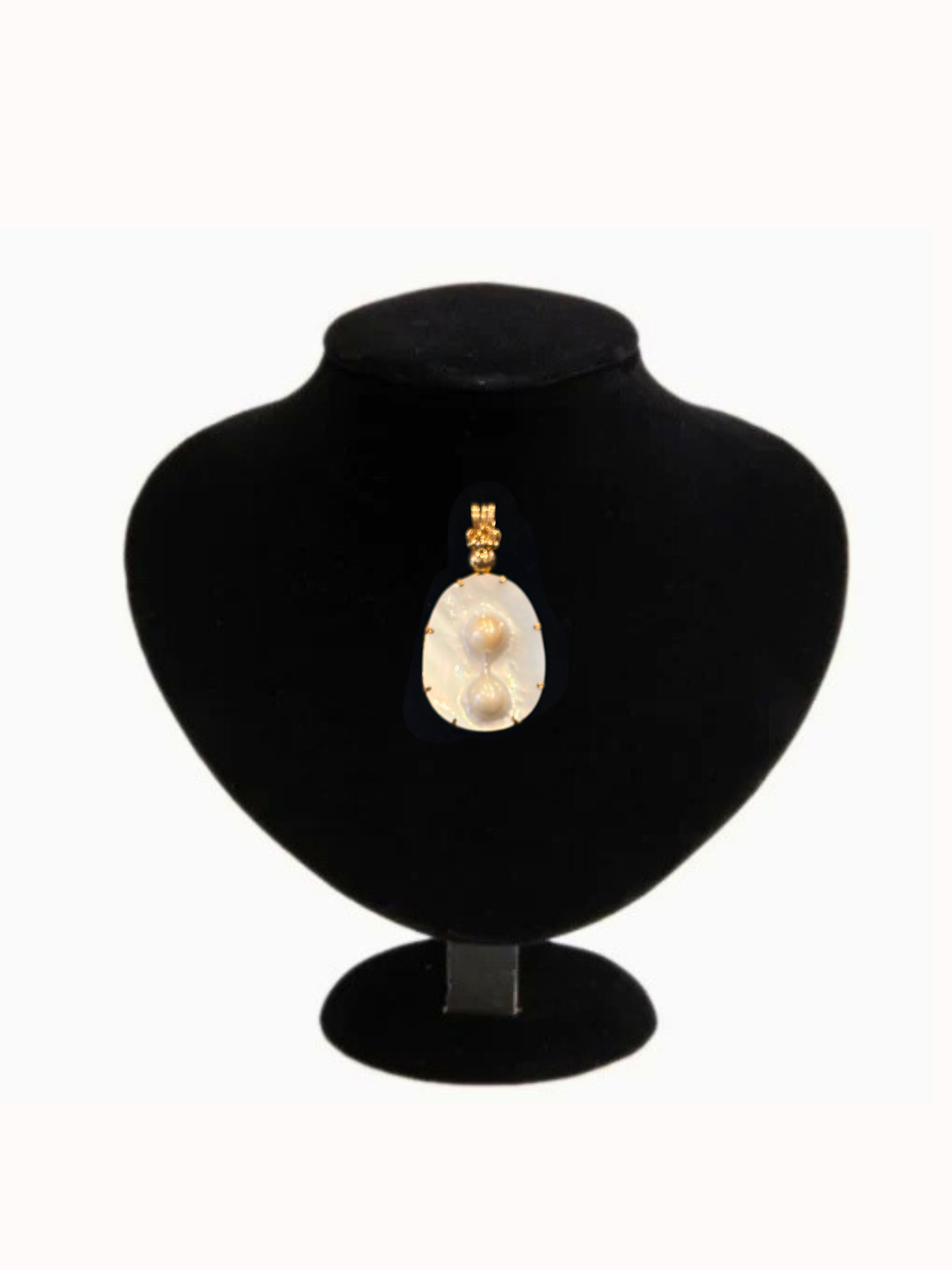Pearl necklace on a black velvet stand against a white background