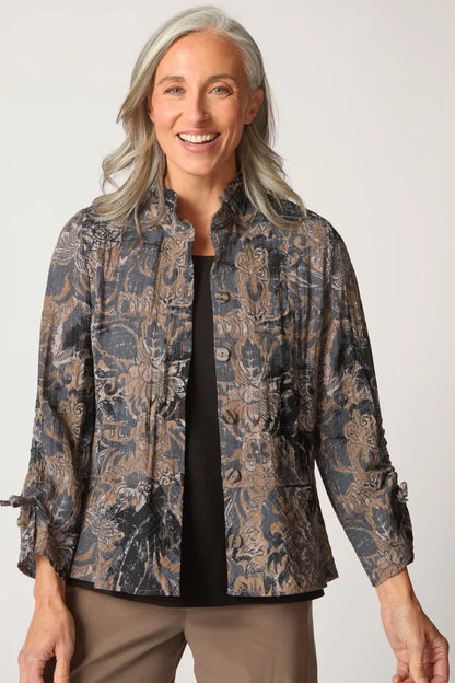 Woman wearing a patterned jacket against a plain background