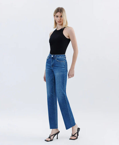 Woman wearing blue jeans and a black top on a white background