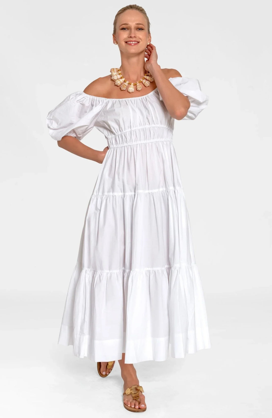 Woman wearing a white dress with ruffled sleeves on a white background