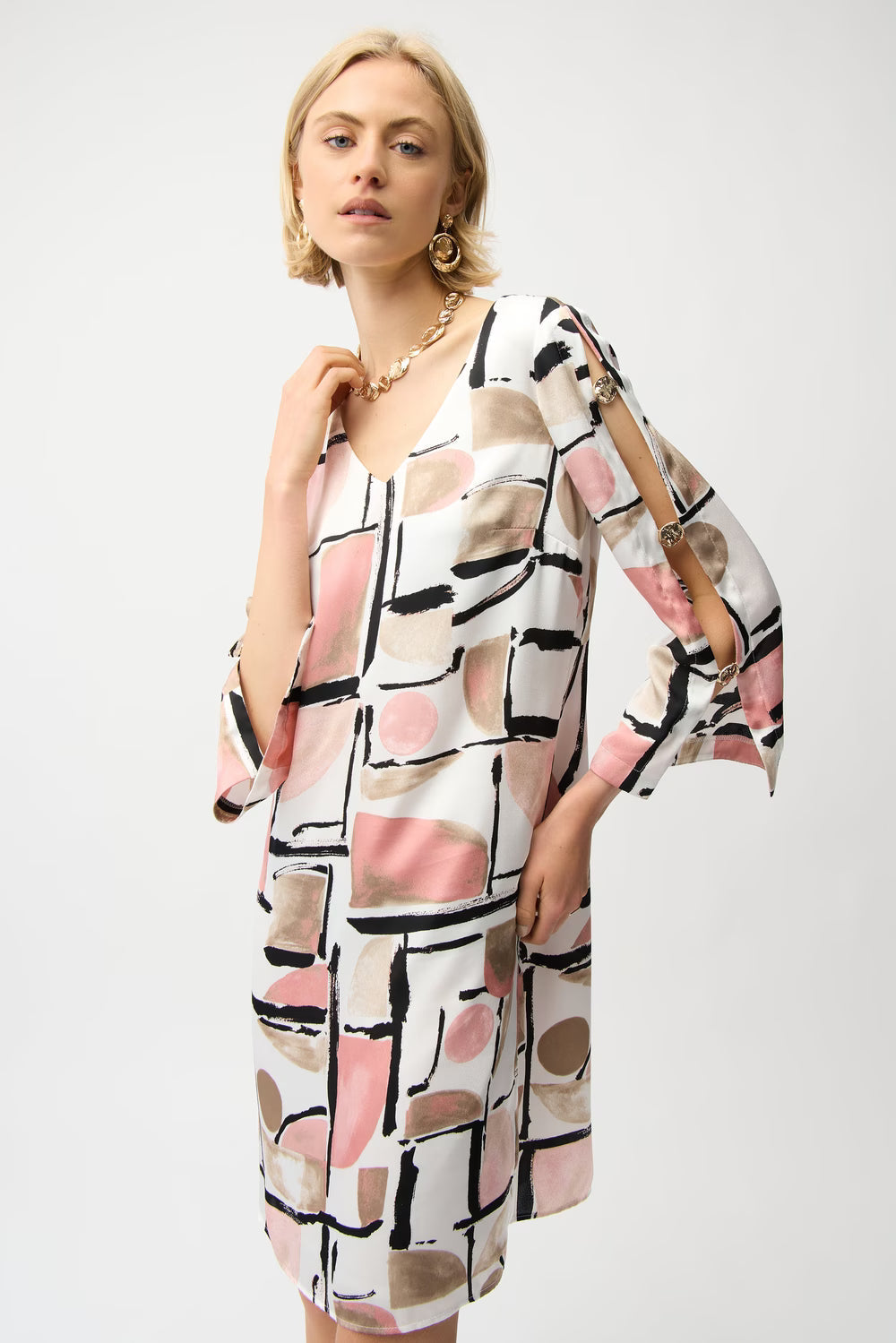 Woman wearing a patterned dress with abstract design on a white background
