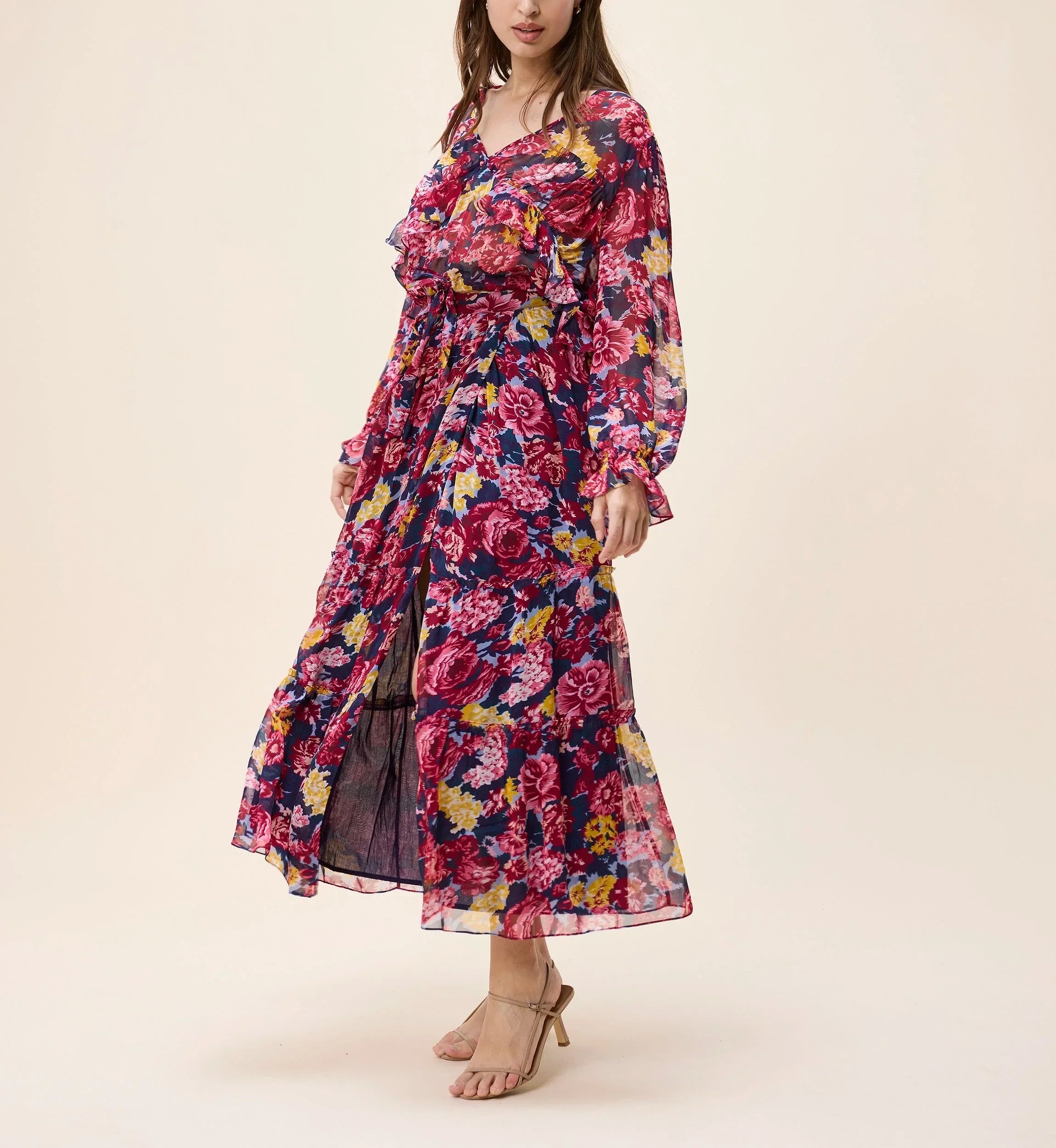 Woman wearing a colorful floral dress on a beige background
