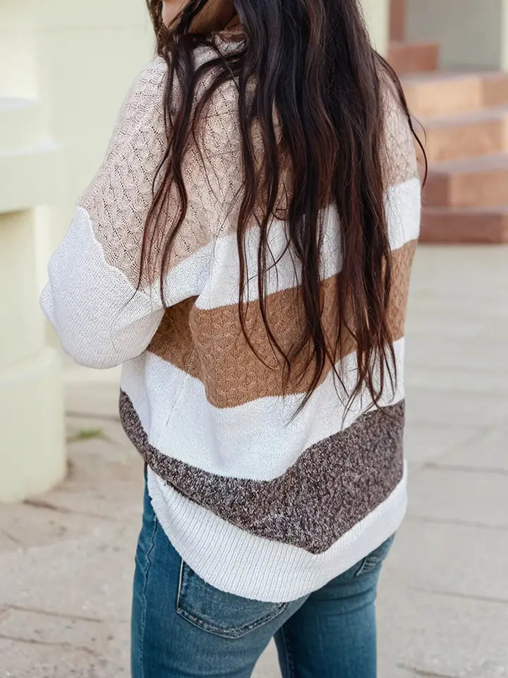 The back of a women in a color block stripped knit sweater in white, light beige, tan, and mocha brown.