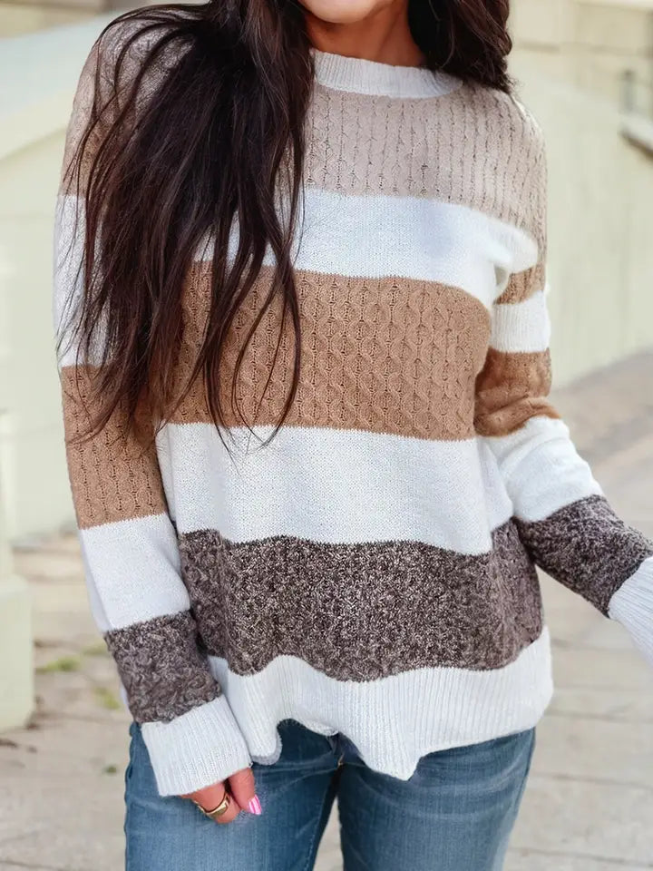 Women in a color block stripped knit sweater in white, light beige, tan, and mocha brown.