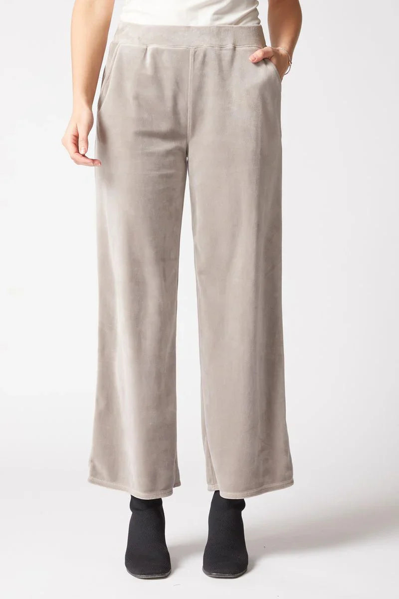 Beige pants worn by a person on a white background