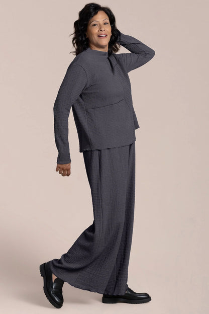 Woman wearing a gray suit on a beige background