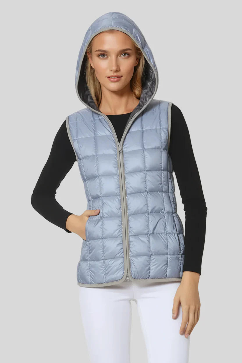 Woman wearing a light blue quilted vest on a white background