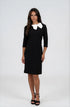 A woman modeling a black knee-length dress with three-quarter sleeves and a contrasting white bow collar