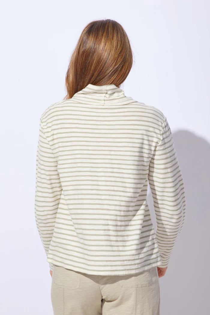 The back of a woman wearing a striped sweater and pants on a plain background
