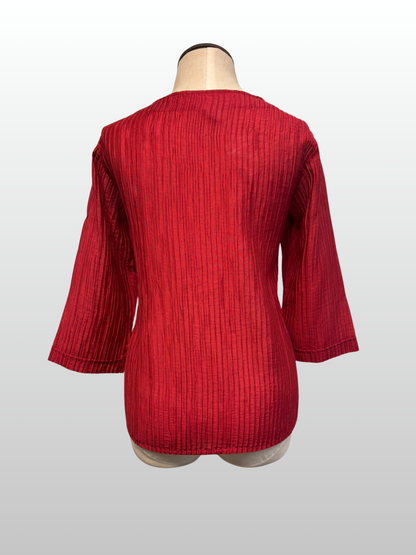 Red textured top on a mannequin against a white background
