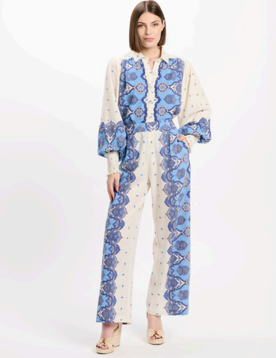 Woman wearing a blue and white patterned outfit on a white background