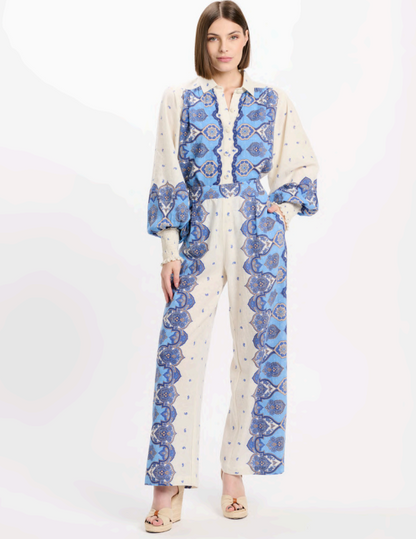 Woman wearing a blue and white patterned outfit on a white background