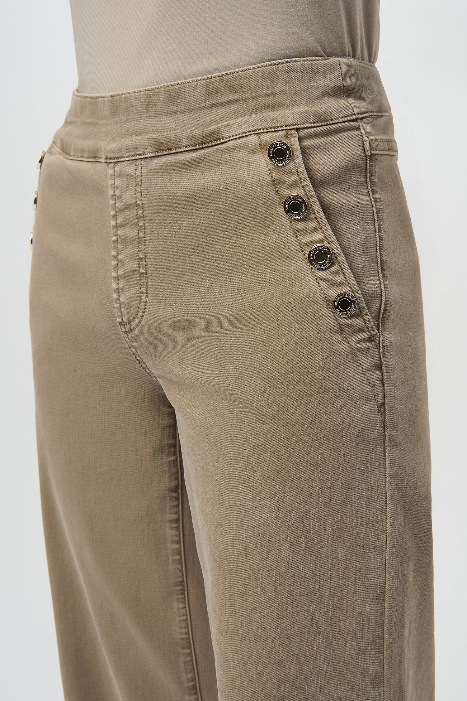 Beige pants with button details on a white background