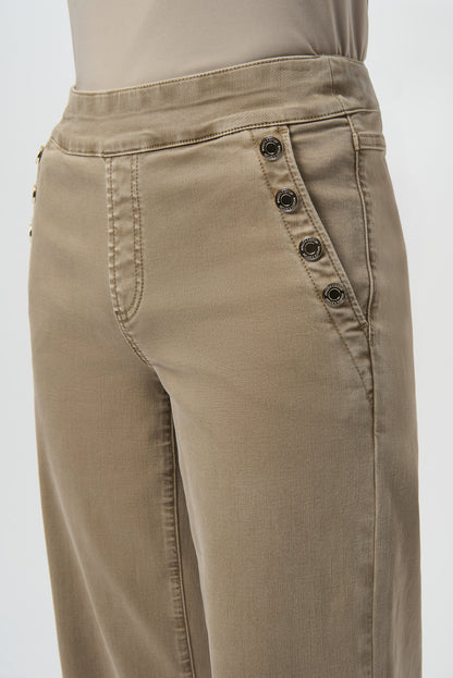 Beige pants with button details on a white background