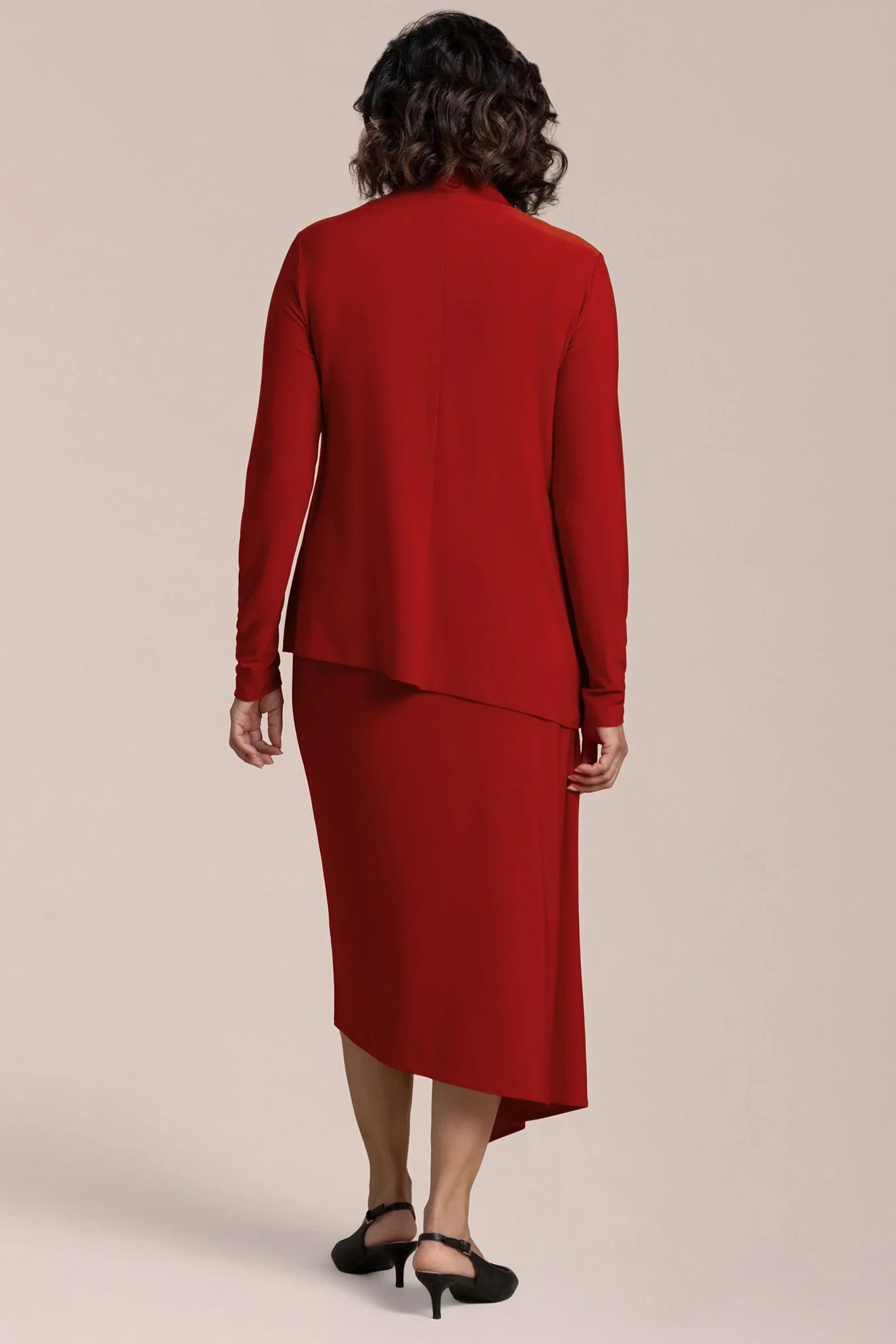 Woman wearing a red suit with a beige background