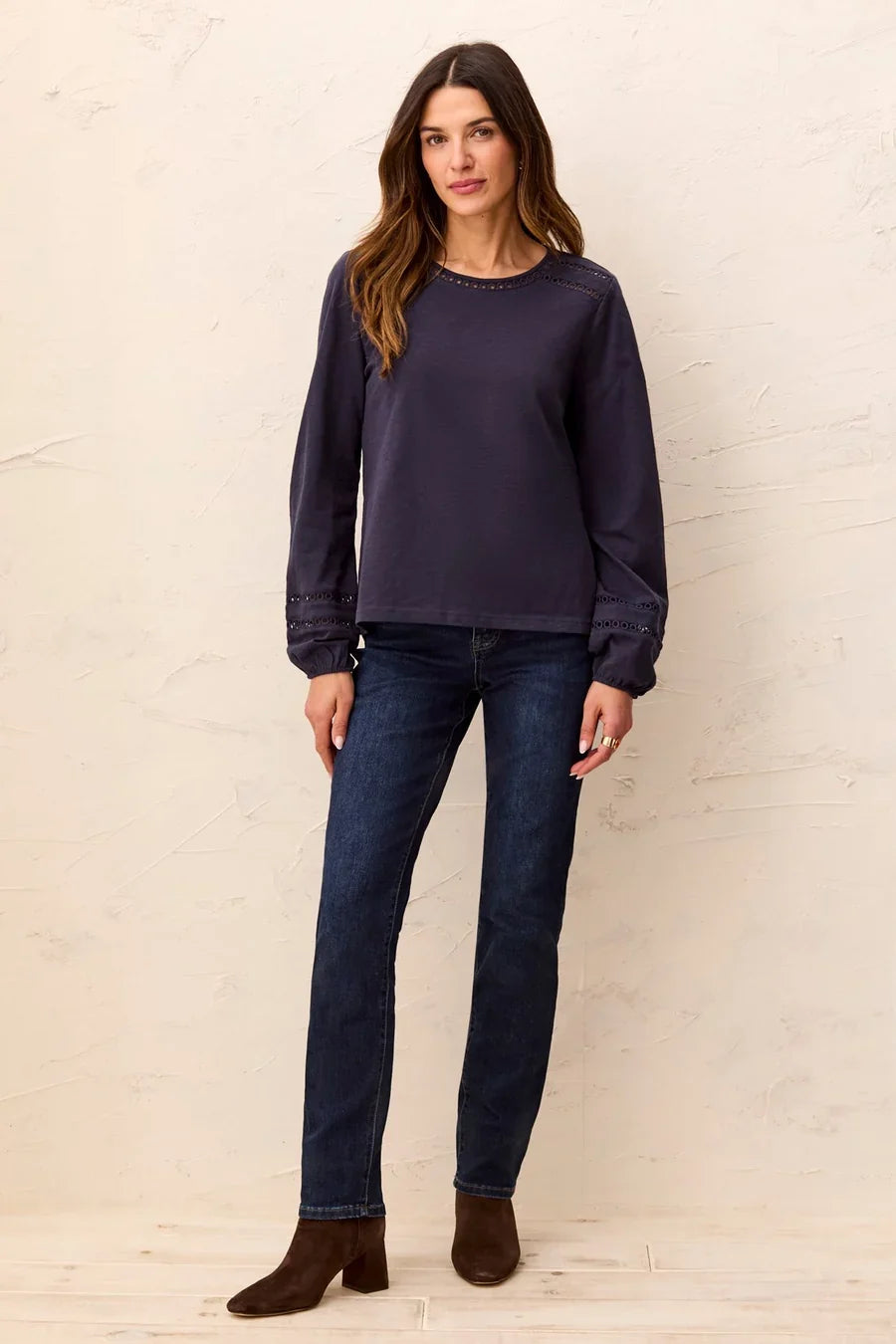 A woman wearing a dark navy blue long-sleeve top with decorative eyelet lace detailing at the neckline and cuffs by tribal Cotton Slub Eyelet Trim Long Sleeve Knit Top