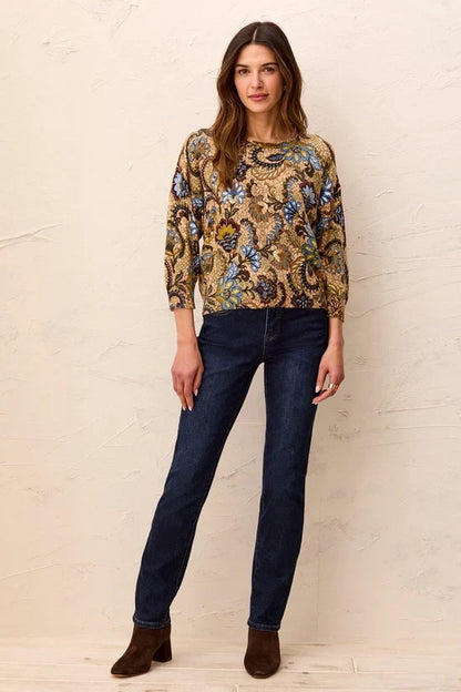 A woman wearing a long-sleeve crewneck top with an intricate paisley and floral pattern in gold, blue, green, and brown by tribal Soft Yarn Three-Quarter Sleeve Crewneck Sweater