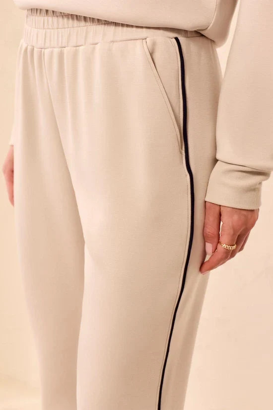 A woman modeling straight-leg pants, featuring thin black side stripes by tribal TECHNO LUX Jogger Pants With Contrast Piping And U-Hem