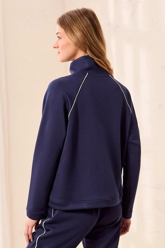 A woman wearing a navy blue quarter-zip sweatshirt with white piping details tribal TECHNO LUX Pop Over Quarter Zip Pullover