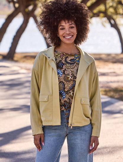 Woman wearing a light green jacket by tribal Soft-Touch Zip-Up Funnel Neck Utility Jacket in the color light pear
