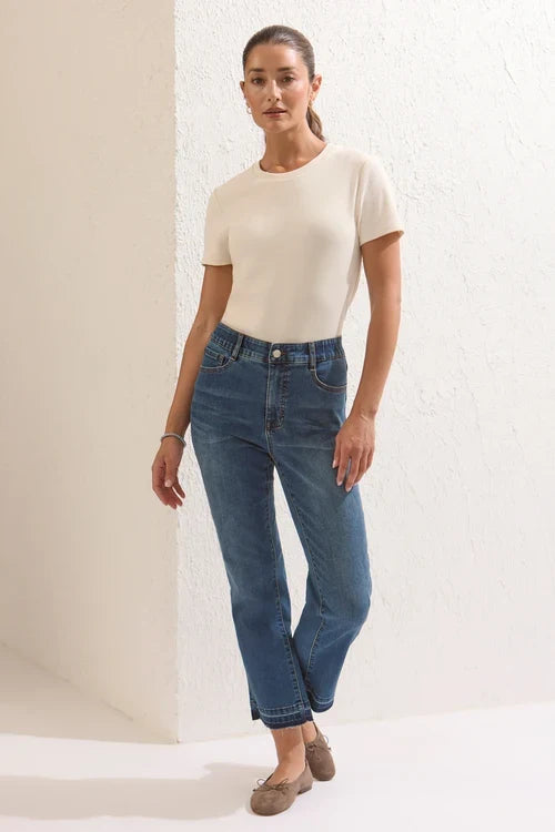 A woman modeling high-waisted blue jeans by tribal Sophia Curvy Micro Flare Jeans in the color dusk