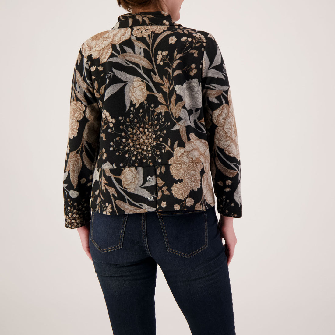 Person wearing a floral patterned jacket on a plain background